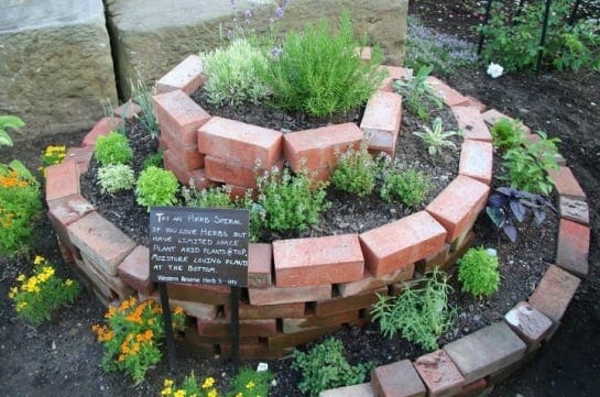 A garden made out of bricks with a sign.