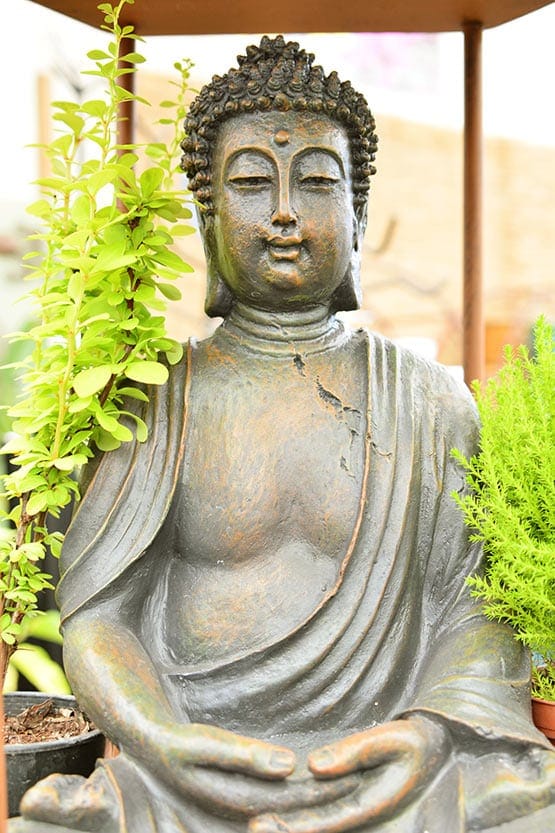A statue of a buddha sitting in a pot.