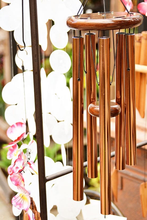 A wind chime hanging from a metal frame.