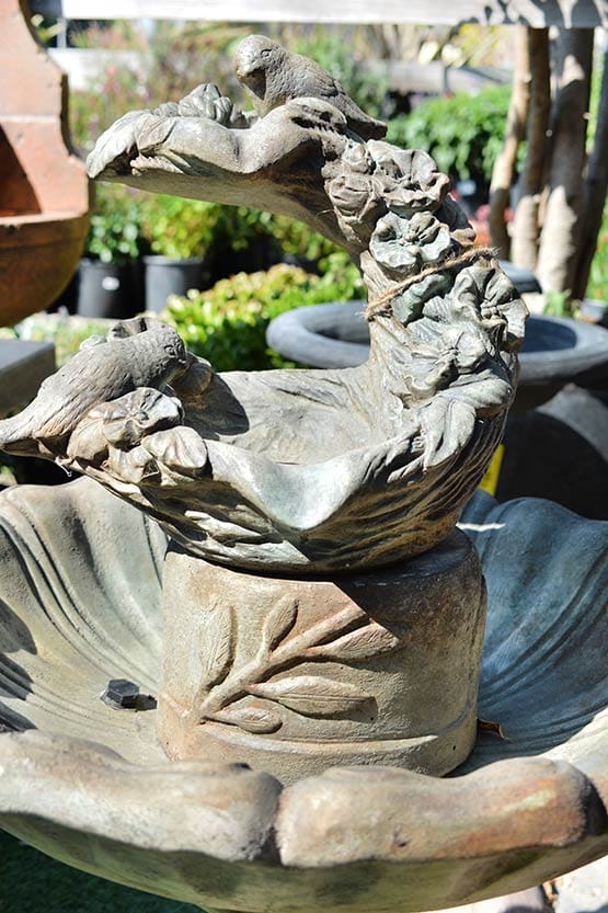 A statue of a bird sitting in a fountain.