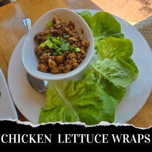 A white plate with fresh lettuce leaves and a bowl of seasoned ground chicken topped with green onions, served with a spoon.