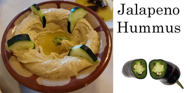 A bowl of jalapeno hummus on a table at a socal garden center.