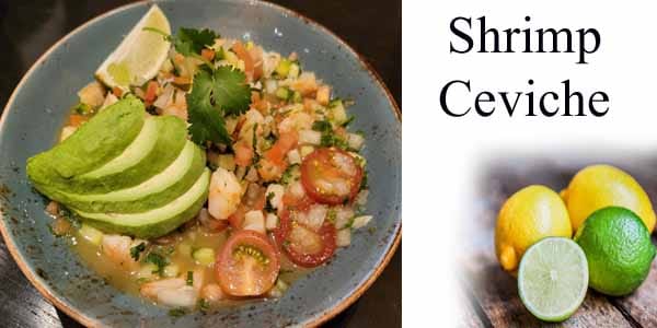 A bowl of shrimp ceviche with limes.