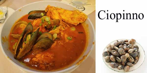 A bowl of soup with clams and seafood in it.