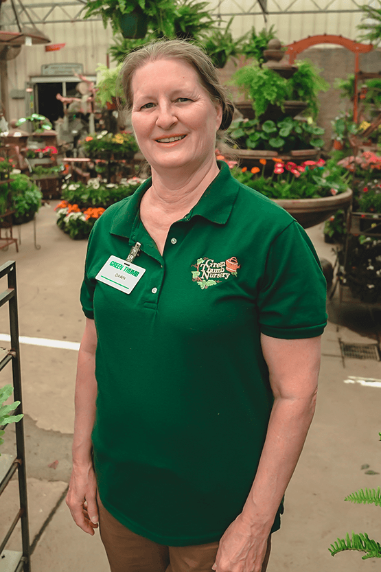 A woman standing in a greenhouse.