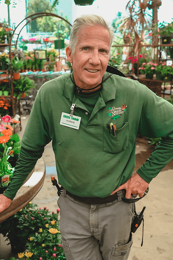 A man in a green shirt standing in front of a flower shop near me.