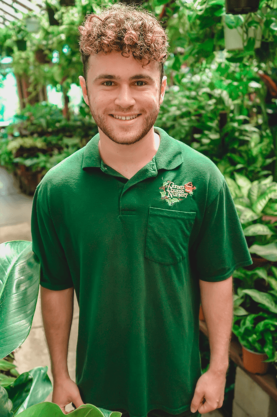 A young man in a green shirt at a garden center near me.