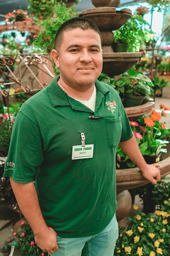 A man in a green shirt standing near a fountain.