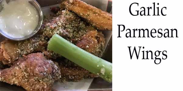 Garlic parmesan wings and celery with dipping sauce.
