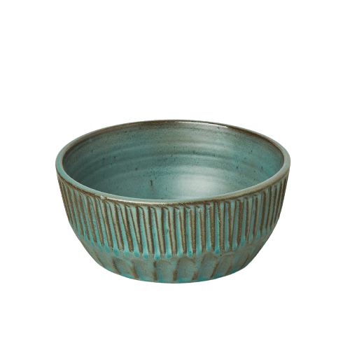 A teal bowl on a black background at one of the best garden nurseries near me.