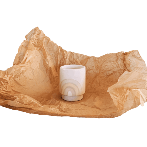 A white cup sitting on a piece of brown paper at the best garden nursery near me.