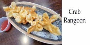 Crab rangoon on a plate with dipping sauce served at a top garden center near me.