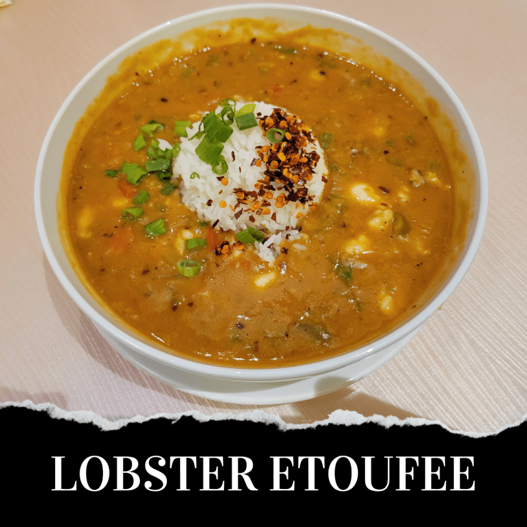 A bowl of lobster etouffee topped with a scoop of white rice, chopped green onions, and crushed red pepper flakes.