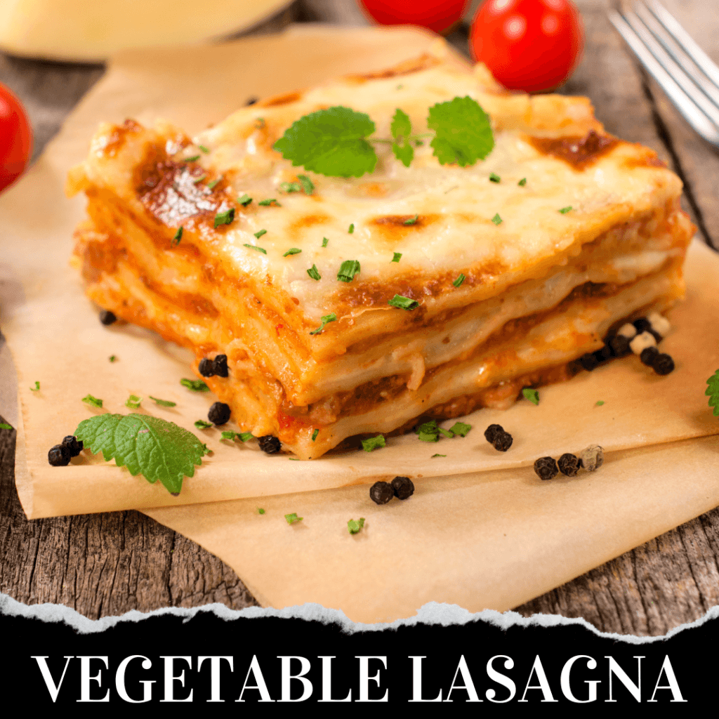 A slice of vegetable lasagna garnished with herbs, placed on parchment paper with black peppercorns and cherry tomatoes in the background.