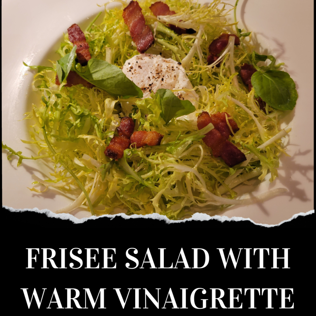 A plate of frisée salad topped with bacon, goat cheese, fresh greens, and a warm vinaigrette, presented on a white dish.