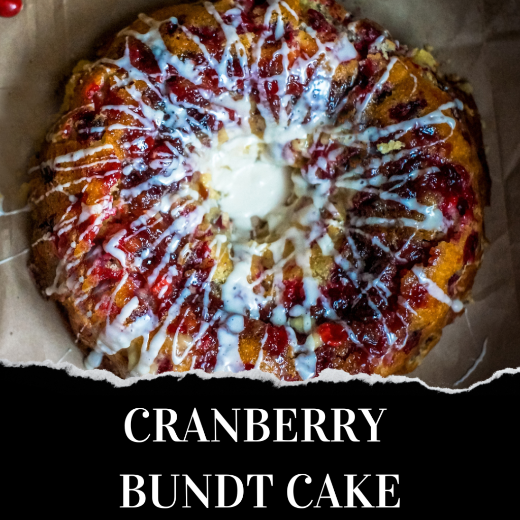 A glazed cranberry bundt cake with a white icing drizzle sits on parchment paper, viewed from above.