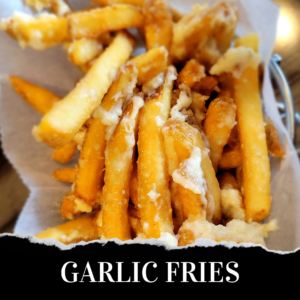 Garlic fries in a basket on a table.