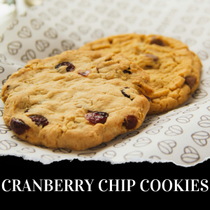 Two cranberry chip cookies on decorative paper with text "CRANBERRY CHIP COOKIES" at the bottom.