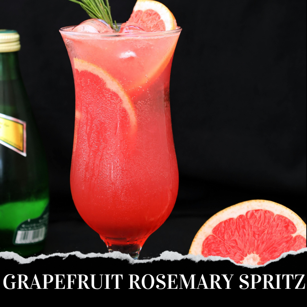 A tall glass with a grapefruit rosemary spritz on a table, garnished with grapefruit slices and rosemary. A grapefruit slice and green bottle are in the background.
