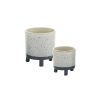 Two ceramic planters with legs, one larger and one smaller, featuring a speckled white finish and dark bases.