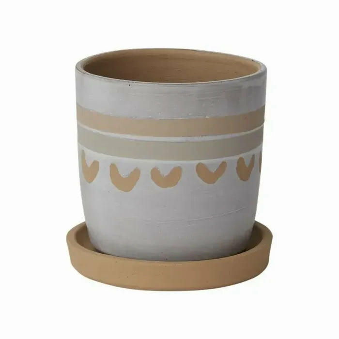Beige and light brown ceramic planter with a matching saucer, featuring a decorative heart pattern around the middle.