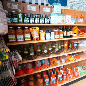 bird feeders 3 A store shelf stocked with assorted bird care products, including seeds, feeders, juice, and feeder accessories in various shapes and sizes.