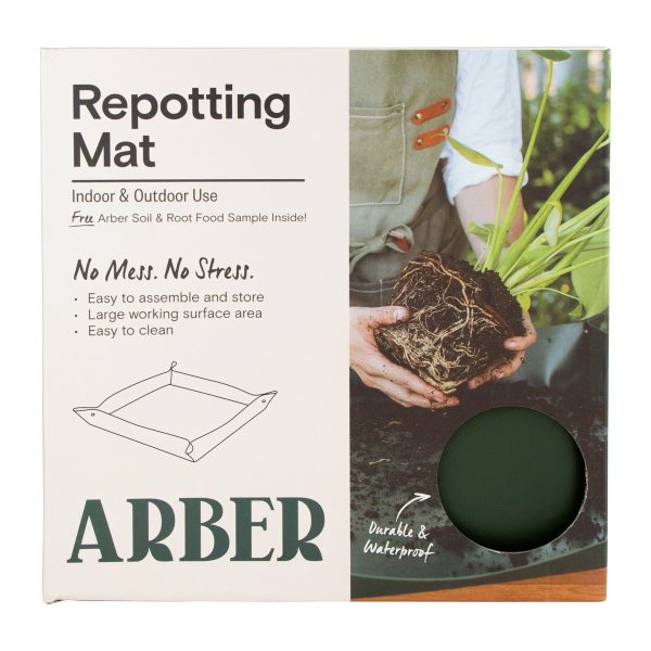 Packaging for an Arber Repotting Mat, showing product features and an image of hands repotting a plant. Box includes a small circular cutout displaying the mat’s color.